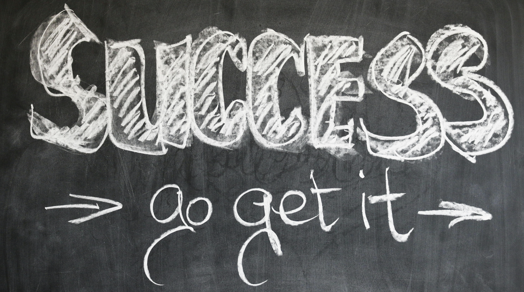 Die Abbildung zeigt eine Kreidetafel mit den Worten SUCCESS - go get it.