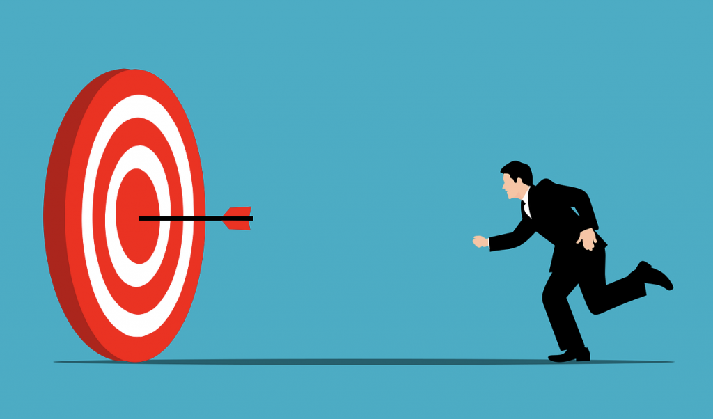 The illustration shows a respectably dressed man throwing a dart accurately into the center of a concentric red and white target.
