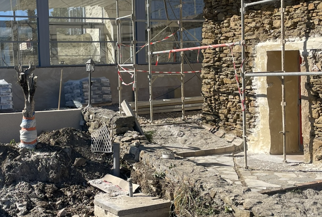 Das Foto zeigt den Arbeitsbereich einer Verputzarbeit an einem alten Steinmauerwerk.